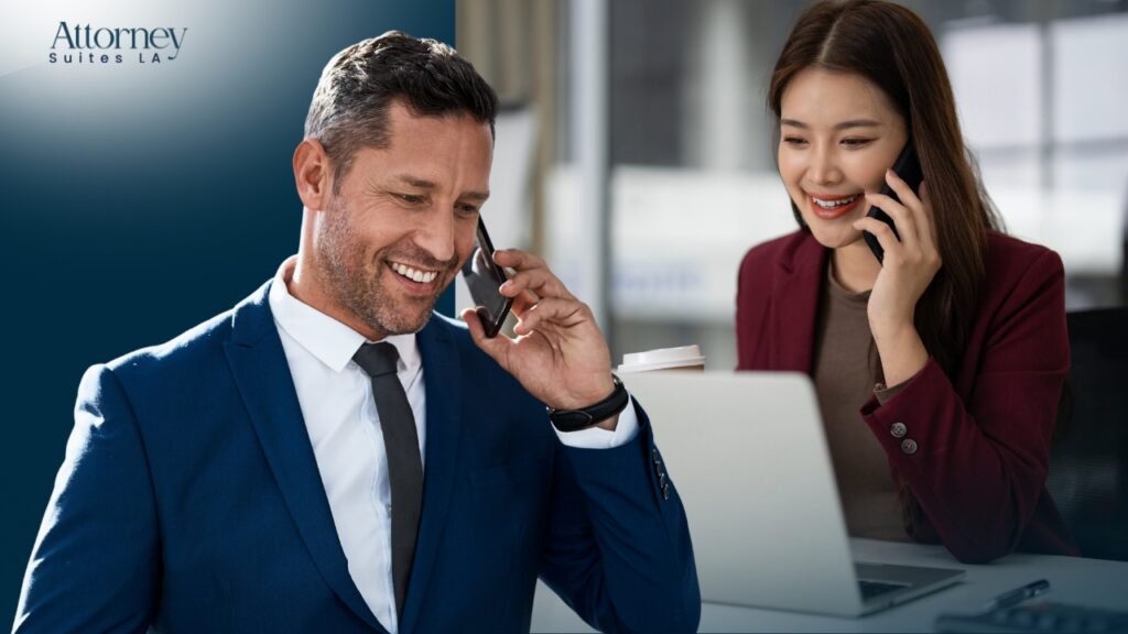 Office Solution for attorneys A man in a blue suit and a woman in a red blazer, both smiling while talking on phones. The woman sits at a desk with a laptop and coffee cup. The logo Attorney Suites LA is in the upper left corner. Los Angeles at Barrister Executive Suites