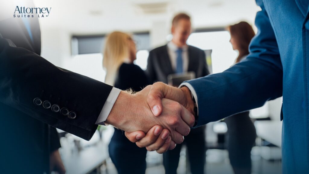 Office Solution for attorneys Two people in suits shake hands in the foreground, while three other professionals stand and converse in the blurred background. Attorney Suites LA logo appears in the upper left corner. Los Angeles at Barrister Executive Suites